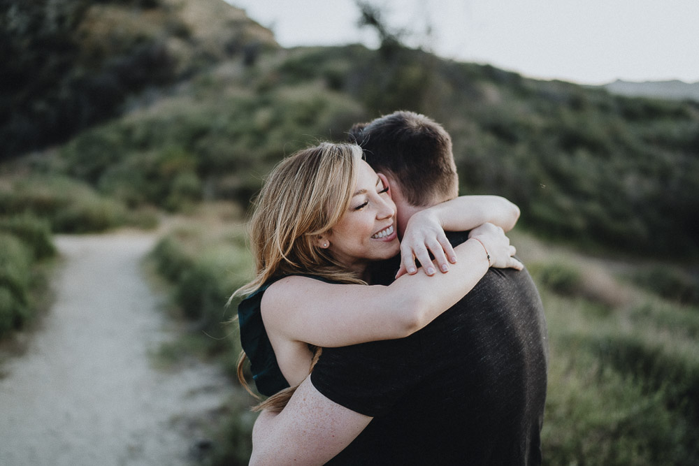 Couple cuddles during engagement session in los angeles canyon