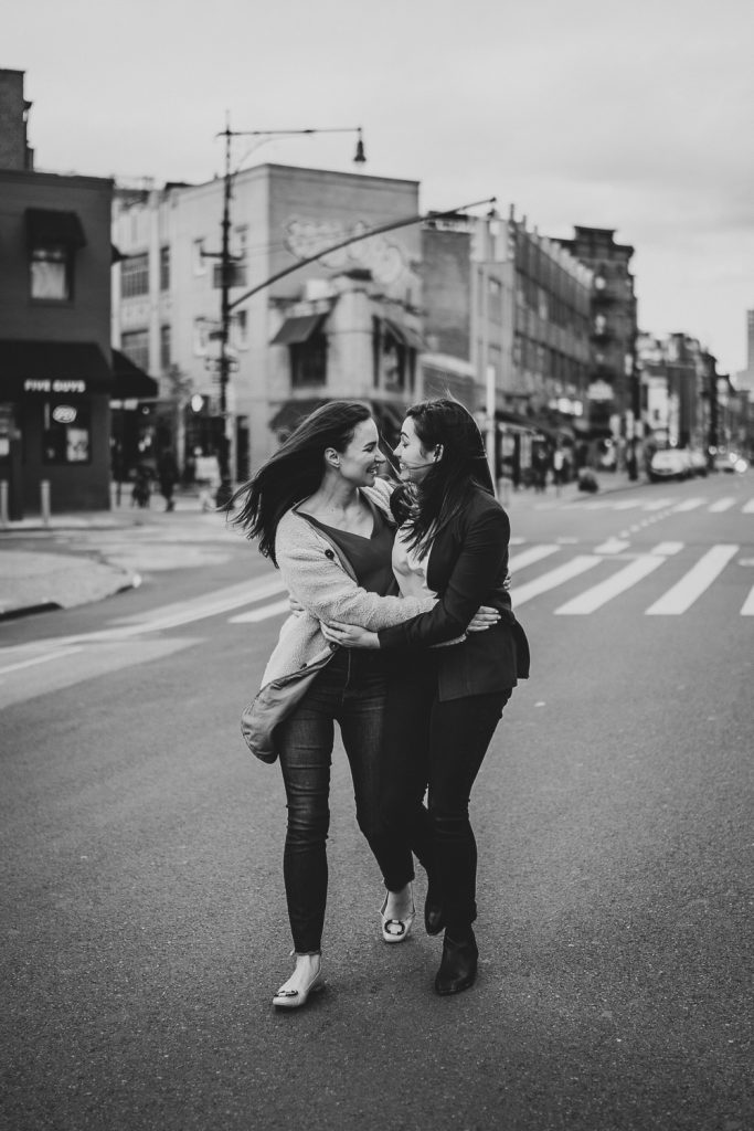 Lesbian couple walking in nyc street during engagement session