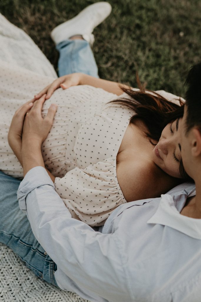Expecting couple snuggles in prospect park during maternity session