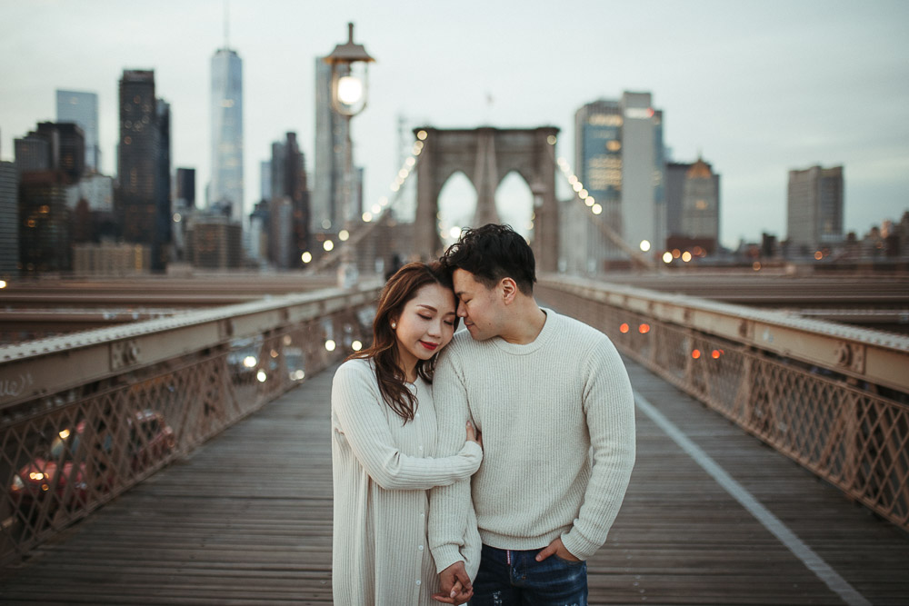 Couple during engagement session on the brooklyn bridge at sunset