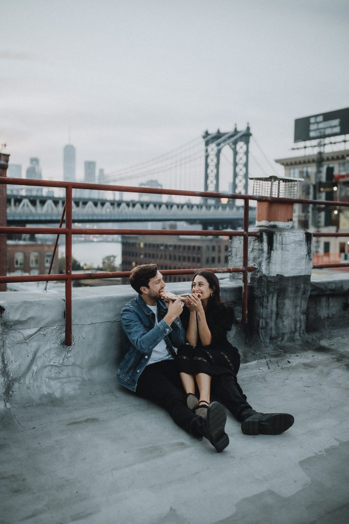 Couple eating pizza during brooklyn rooftop engagement session