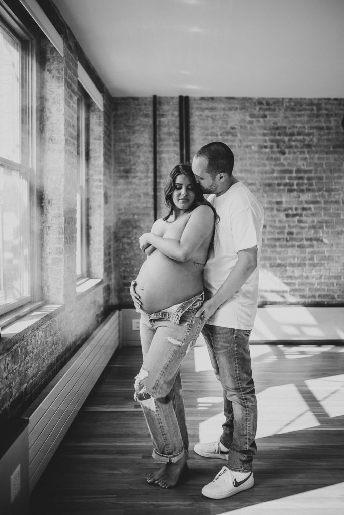 Expecting couple during intimate maternity session in nyc home