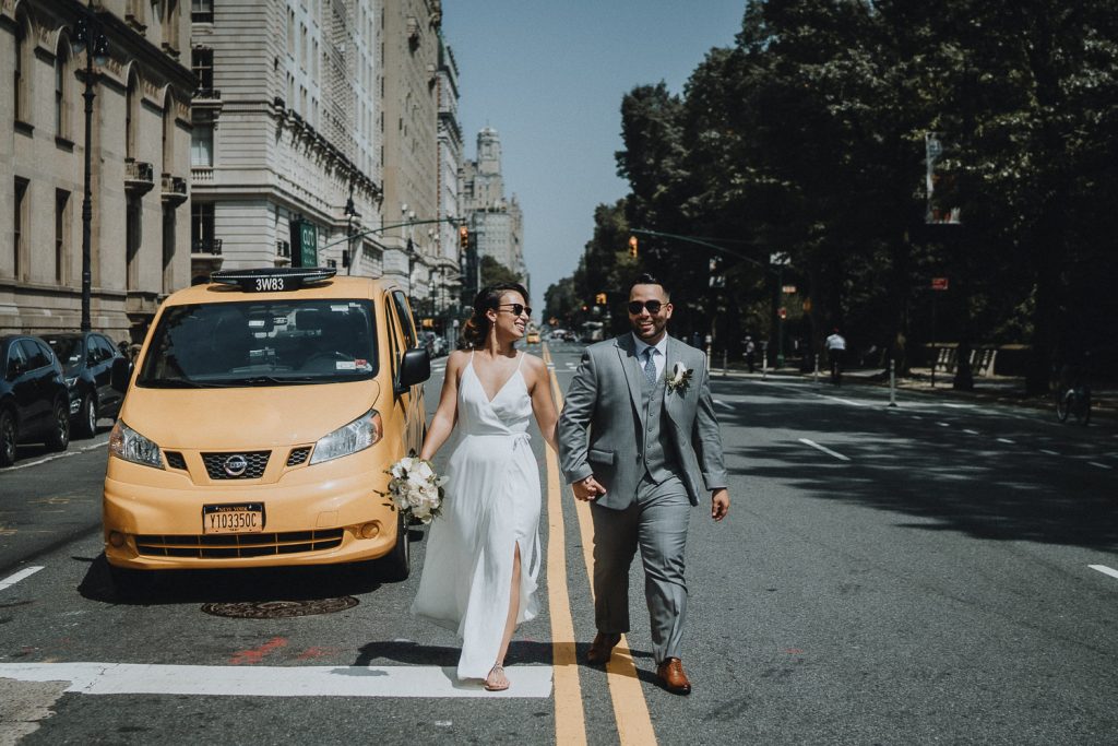 Bride and groom by yellow taxi cab in nyc on wedding day