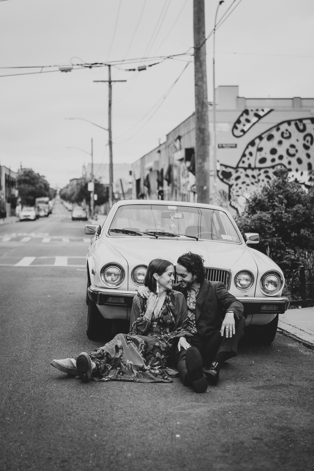 Couple sitting against old vintage car during brooklyn elopement