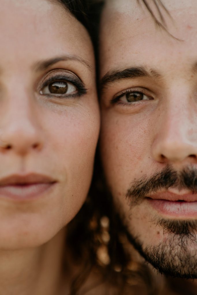 Close up of bride and groom's faces looking at photographer