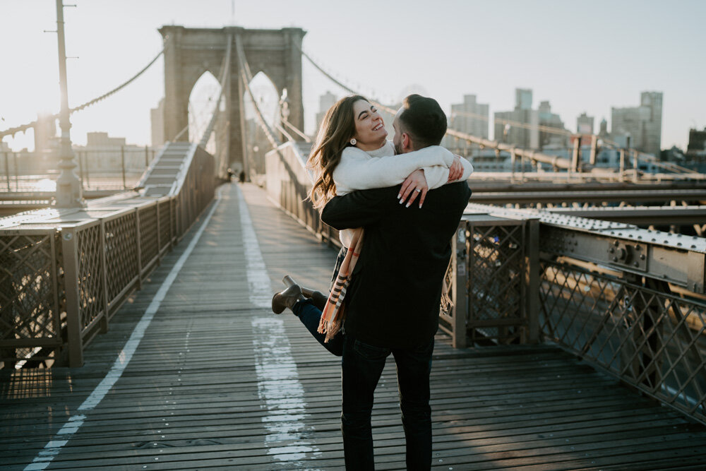 Man carries girlfriend on brooklyn bridge during engagement session