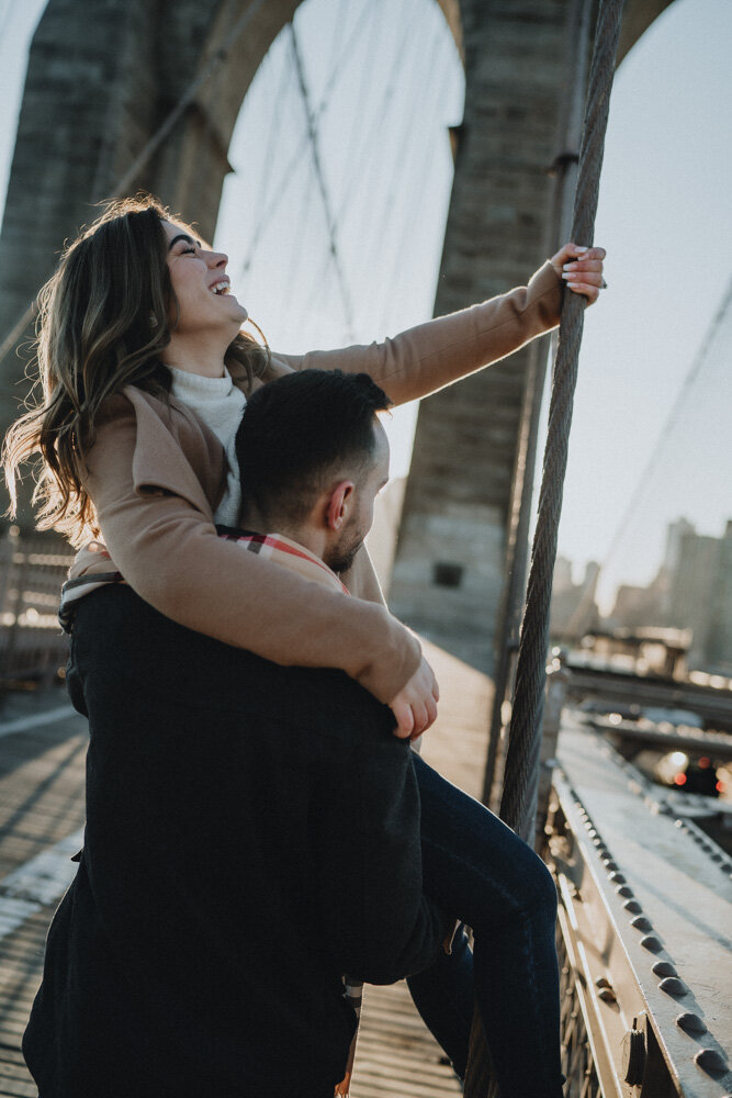 Couple goofing around on brooklyn bridge during engagement session