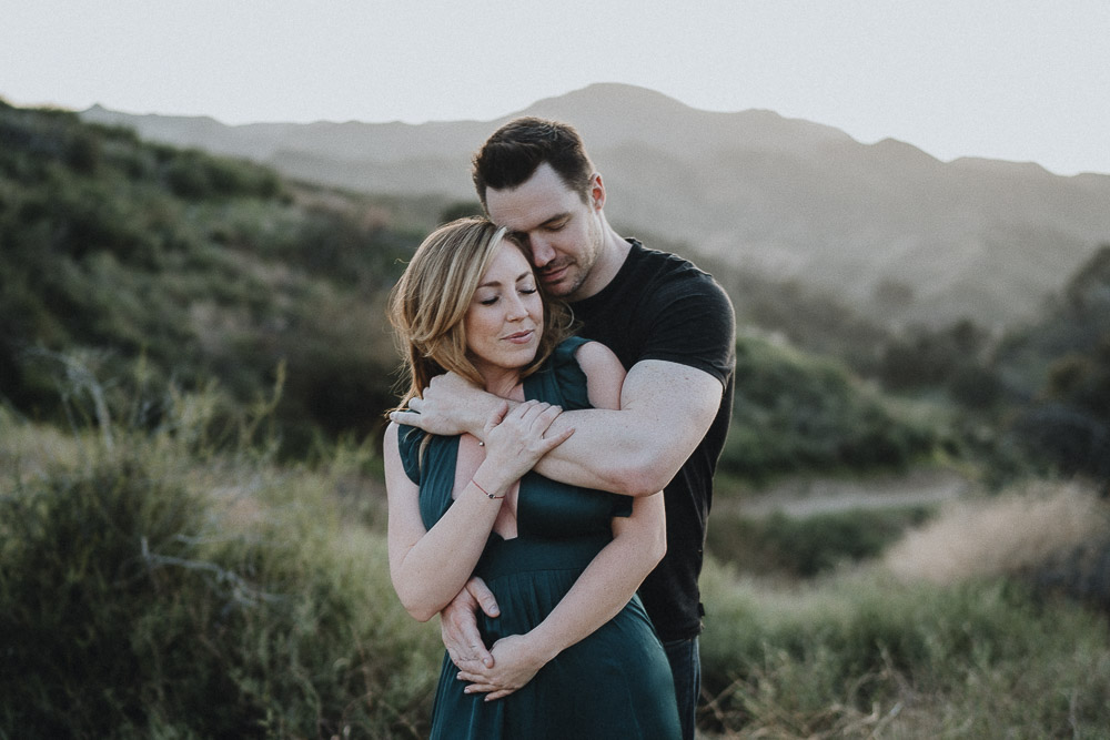 Couple cuddles during engagement session in los angeles canyon