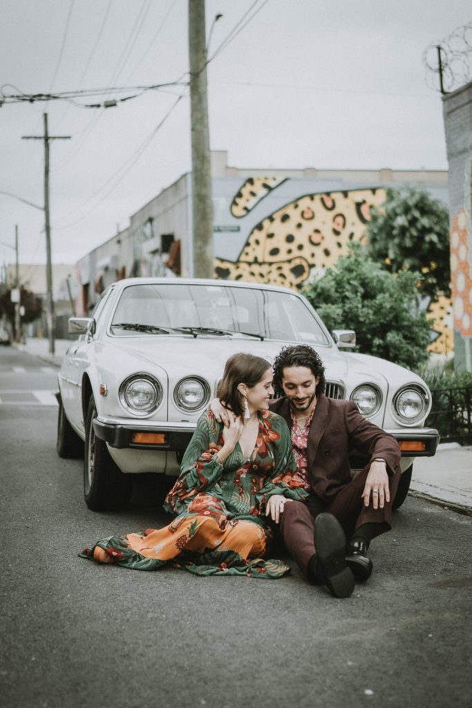 Couple sitting against old vintage car during brooklyn elopement