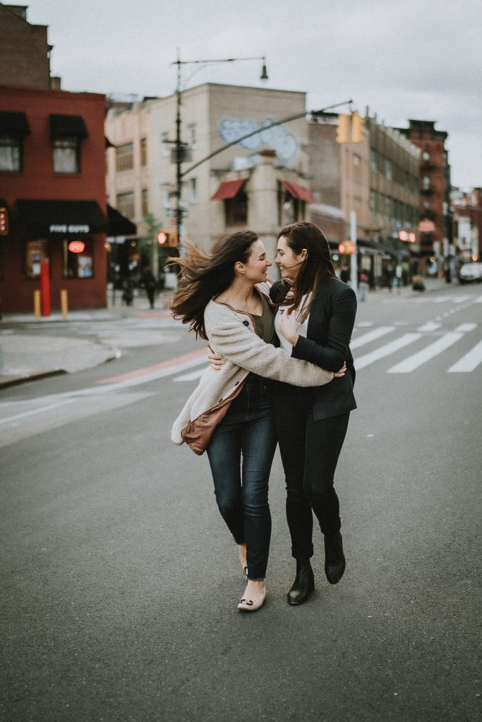 Lesbian couple walking in nyc street during engagement session