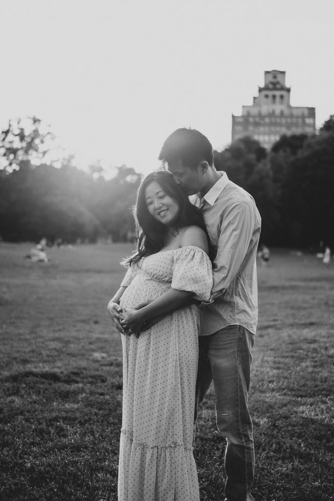 Expecting couple snuggles in prospect park during maternity session