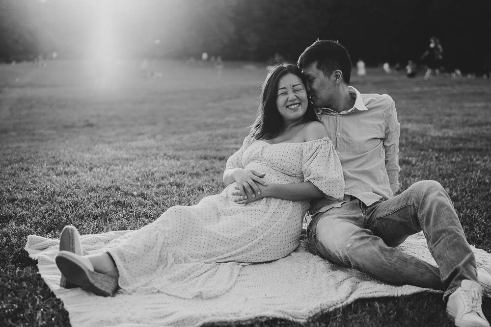 Expecting couple laughs in prospect park during maternity session