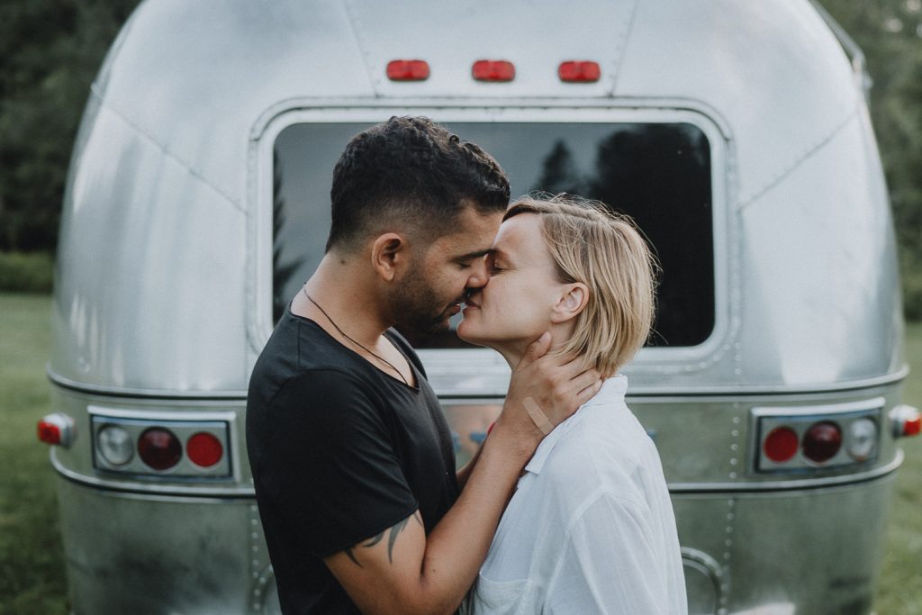Couple kissing in front of airstream during engagement session upstate new york