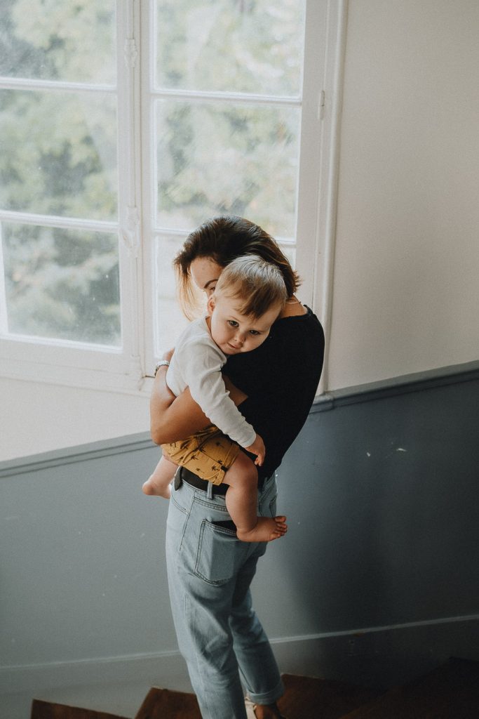 Mom hugging son in staircase during family session in paris