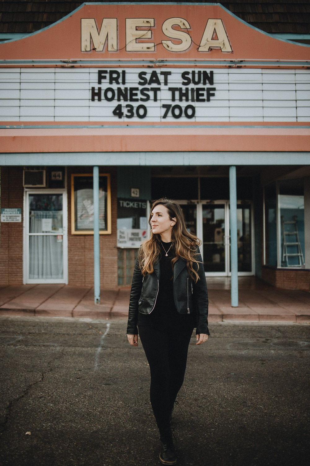 Woman in front of old cinema for vintage vibe portrait session