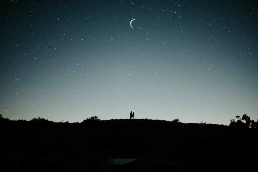 Couple under the stars and moon at blue hour