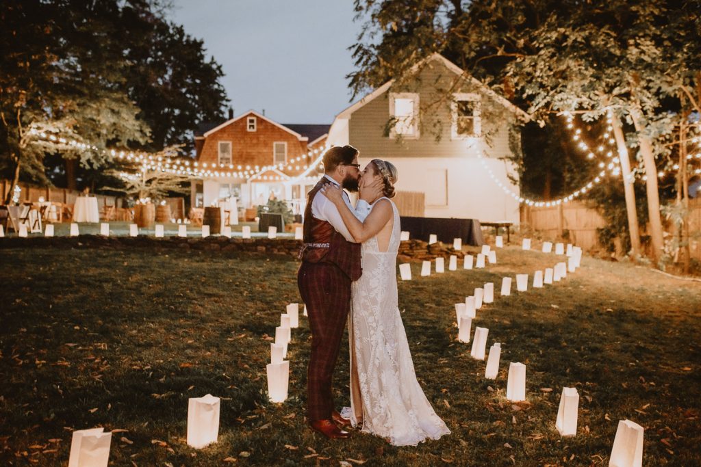 Bride and groom at backyard wedding with lanternas and bistro lights