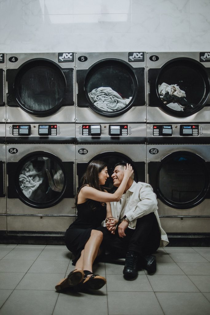 Couple during engagement photo session at laundromat in williamsburg