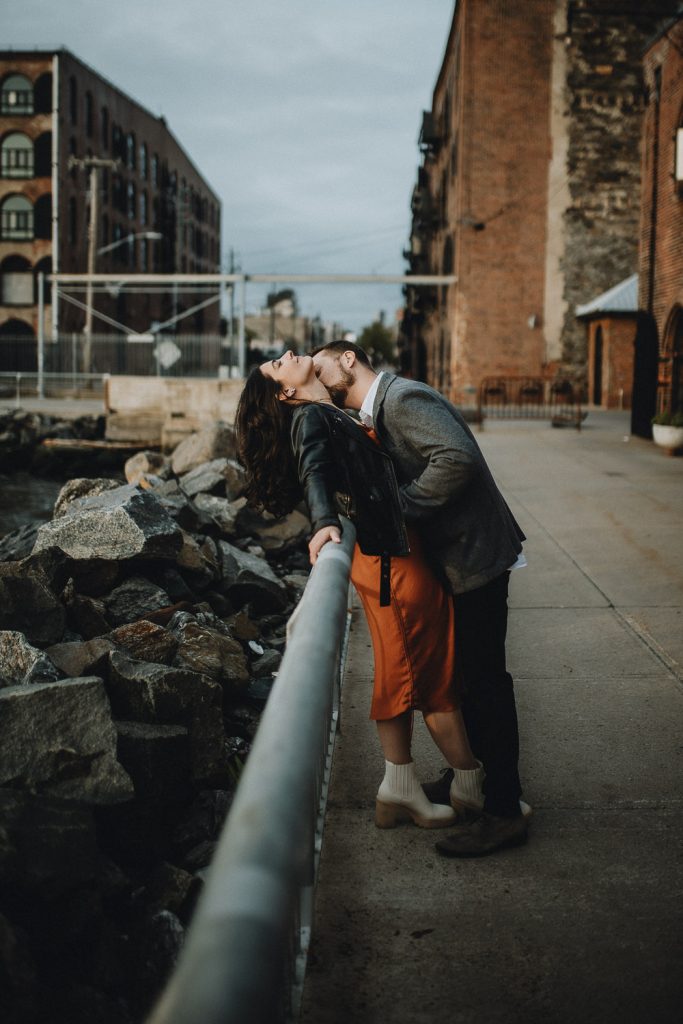 Couple taking engagement photos in brooklyn red hook
