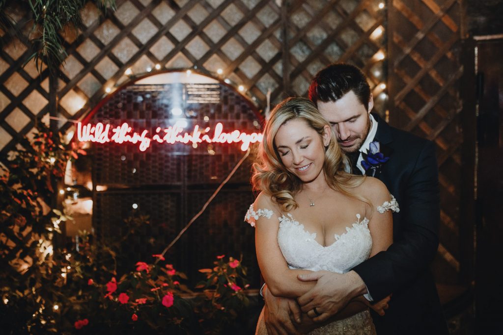 Bride and groom flash portrait with neon sign at los angeles wedding