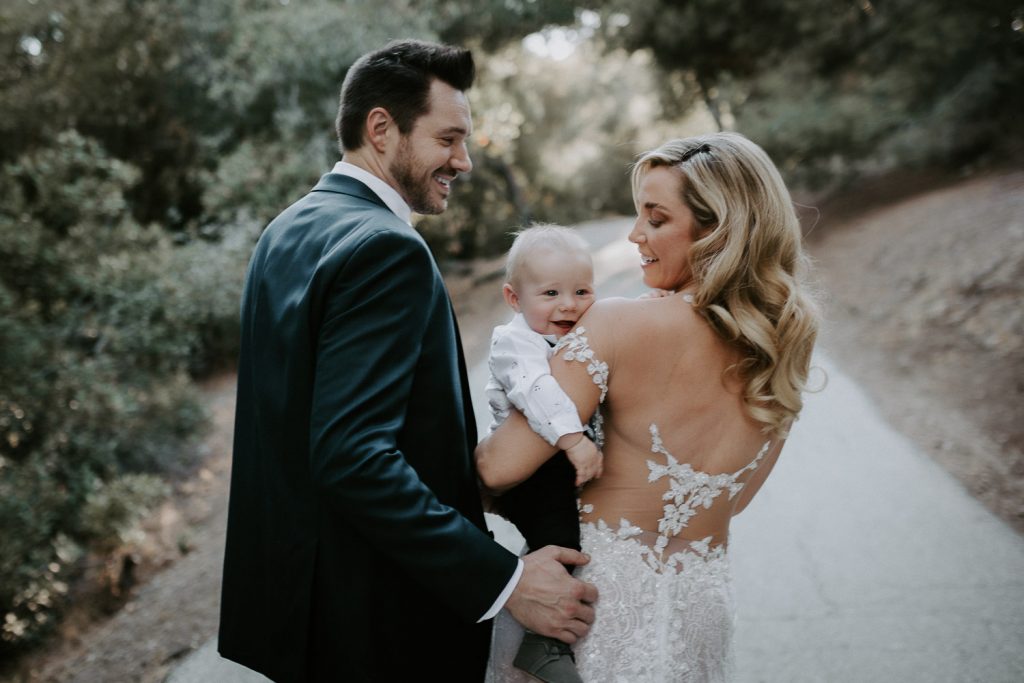 Bride and groom with their baby in hills of los angeles
