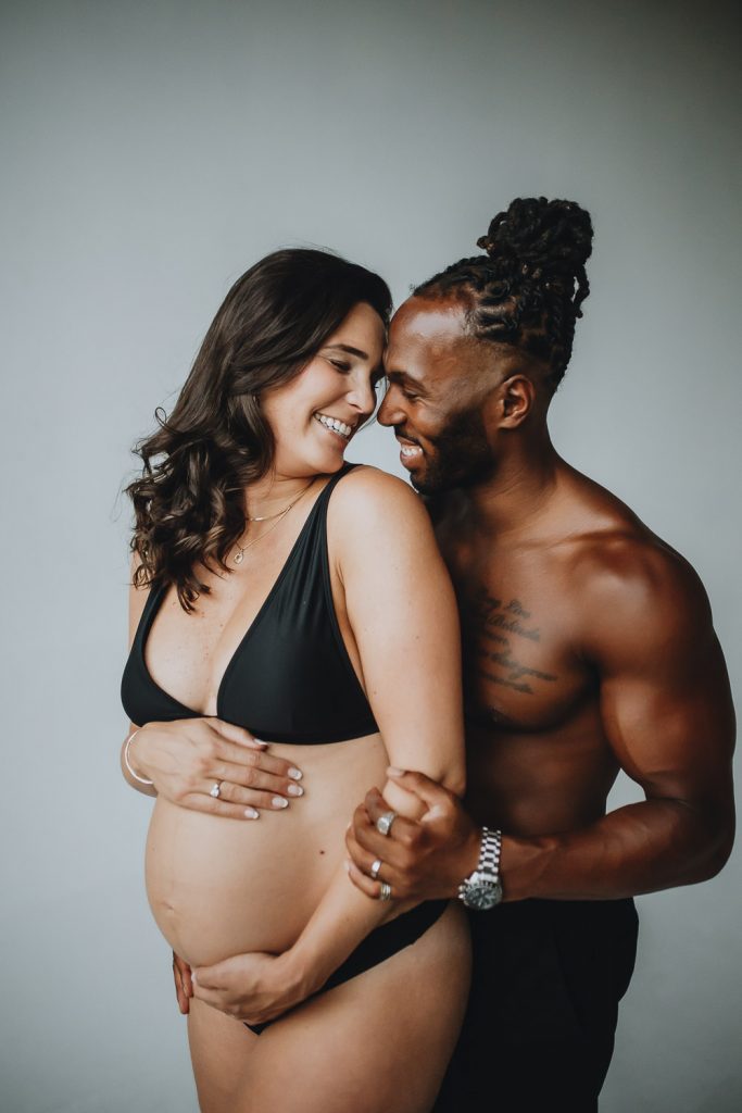 Interracial couple during intimate maternity photoshoot in brooklyn studio