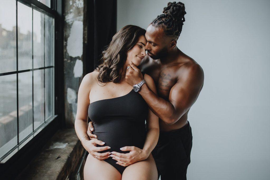 Interracial couple during intimate maternity photoshoot in brooklyn studio