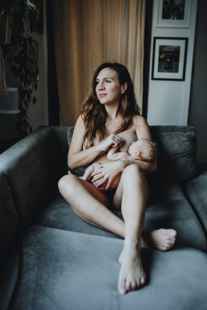 Mother breastfeeding newborn during in home session in brooklyn