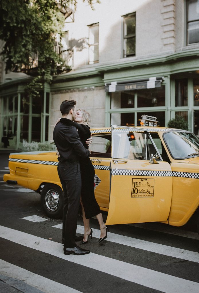 Couple during nyc engagement photoshoot in vintage taxi cab