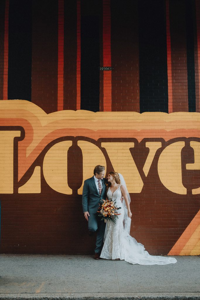 Bride and groom by nyc mural on wedding day