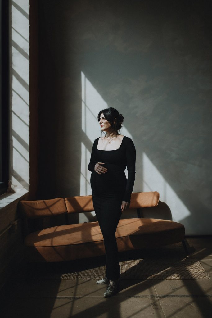 Studio maternity photoshoot in direct light and shadows