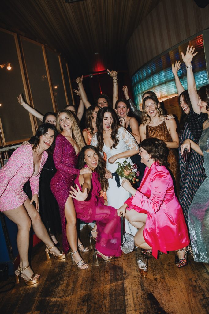 Fun bridesmaids on dance floor with mismatched dresses
