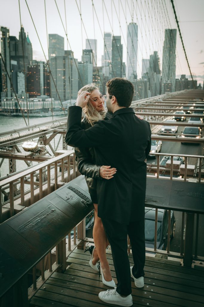 Couple during romantic engagement photoshoot on brooklyn bridge