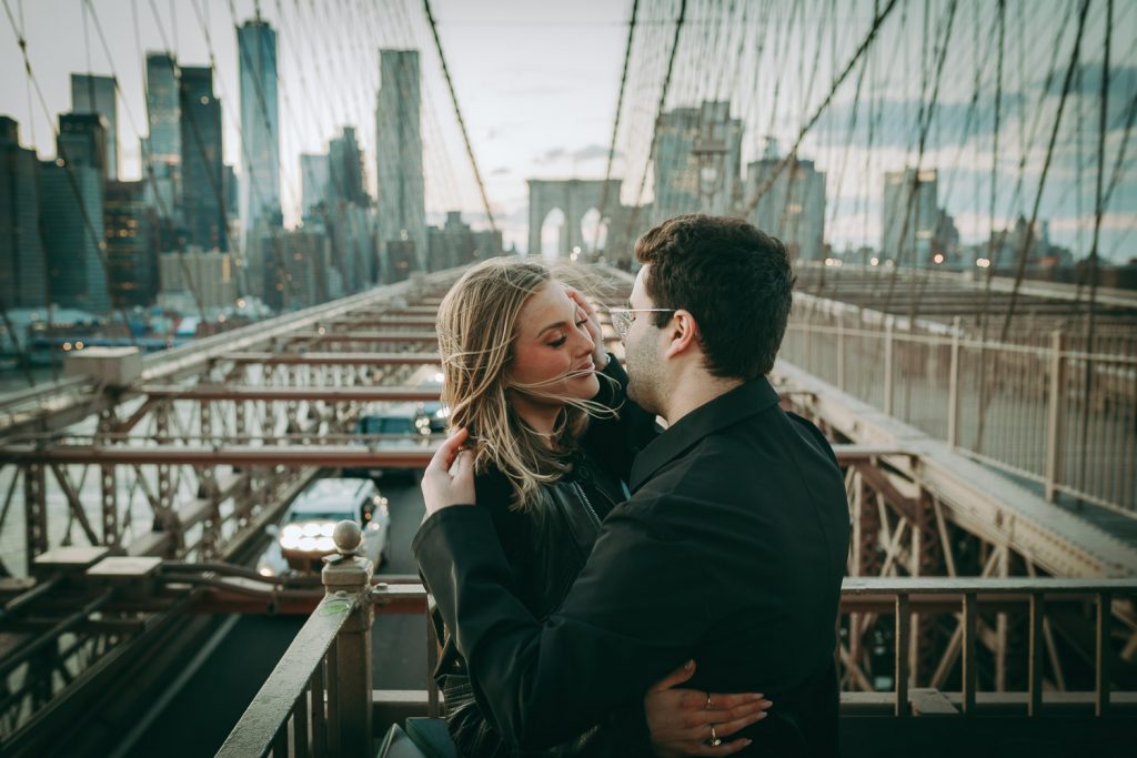 Couple during romantic engagement photoshoot on brooklyn bridge
