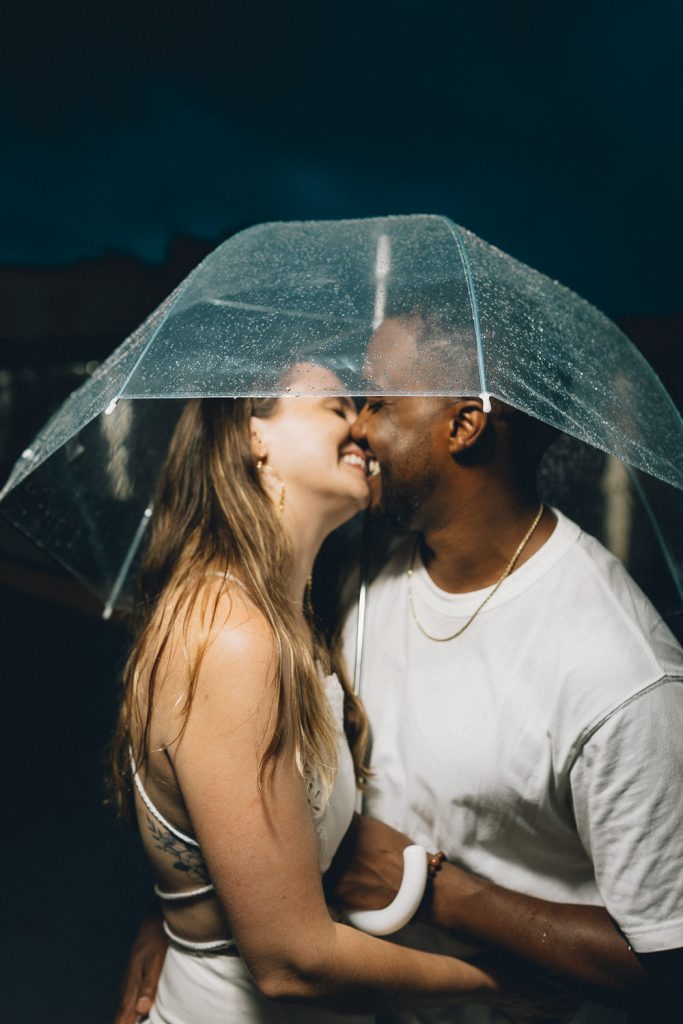 Rainy engagement session in nyc under clear umbrella
